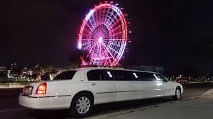 Stretch limousine white color parked outside a theme partk 