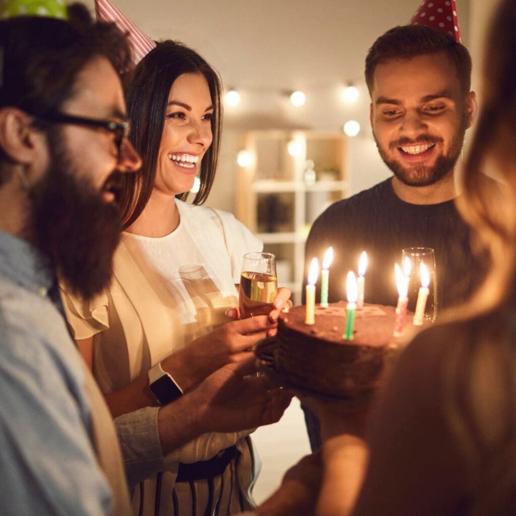 Youngsters celebrating birthday with cake full of candles